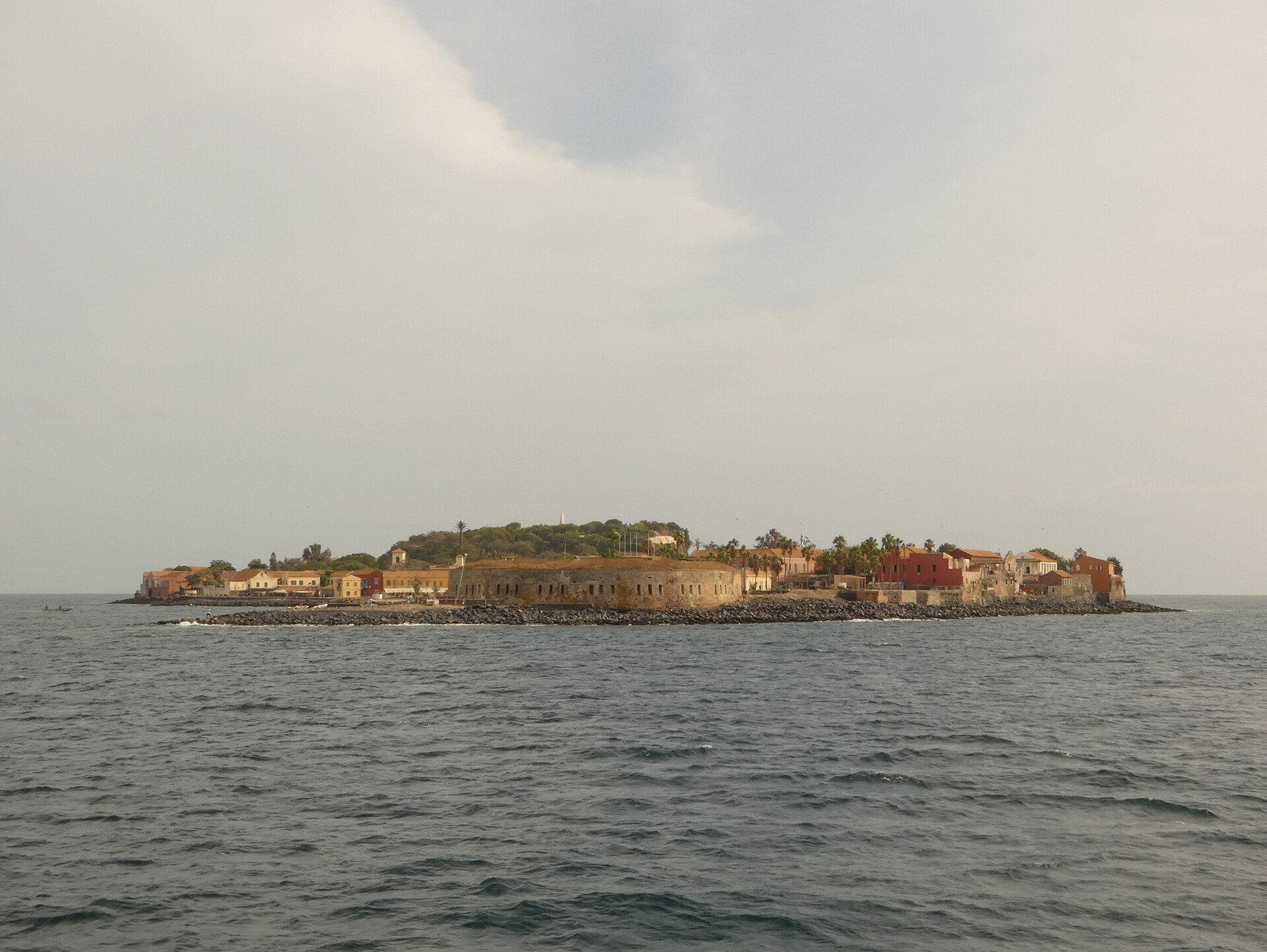 Gorée seen from the water, with low coloured houses along the shore.
