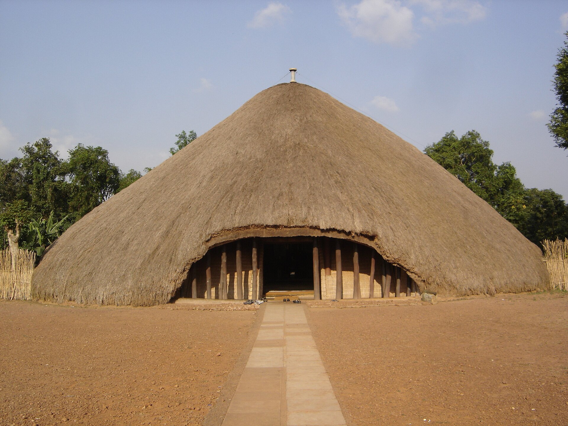 A large round thatched building with a dark arched entrance.